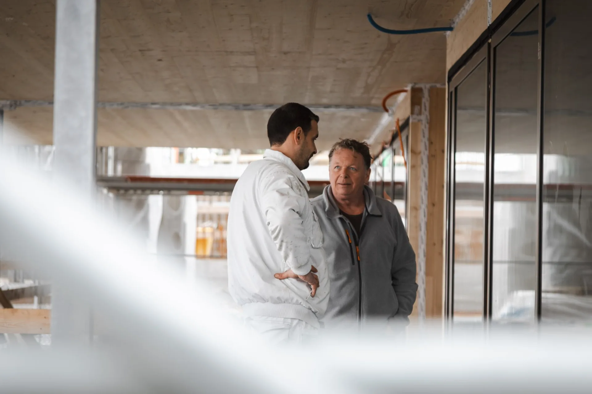 Zwei Mitarbeiter von RF Bau im Gespräch auf der Baustelle